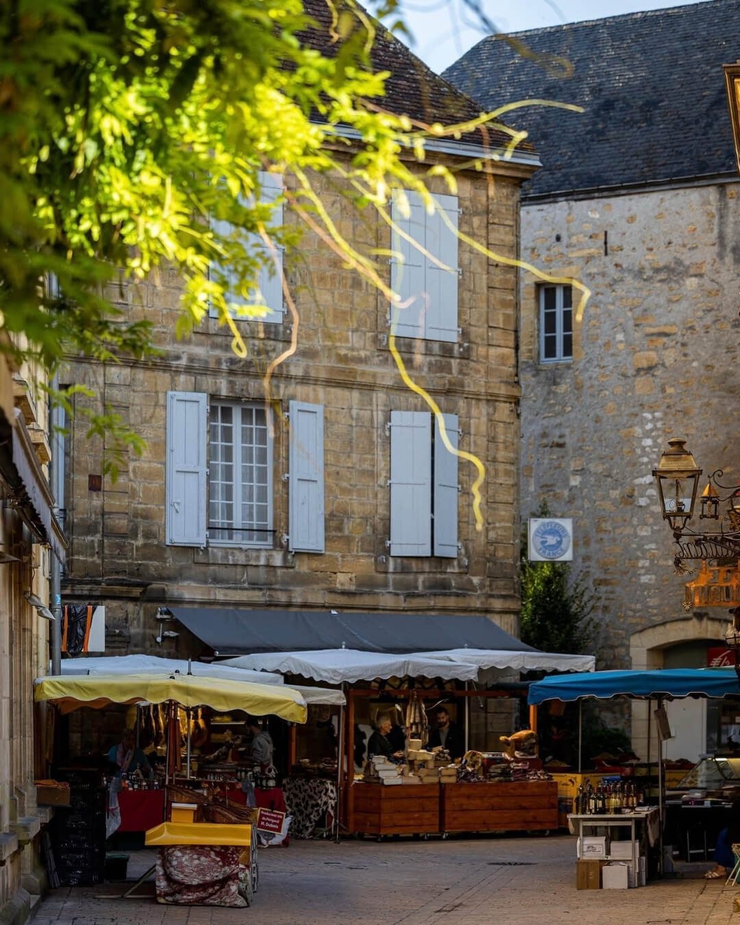 Le Marché de Sarlat in the Périgord Noir with covered market stalls in the town square.