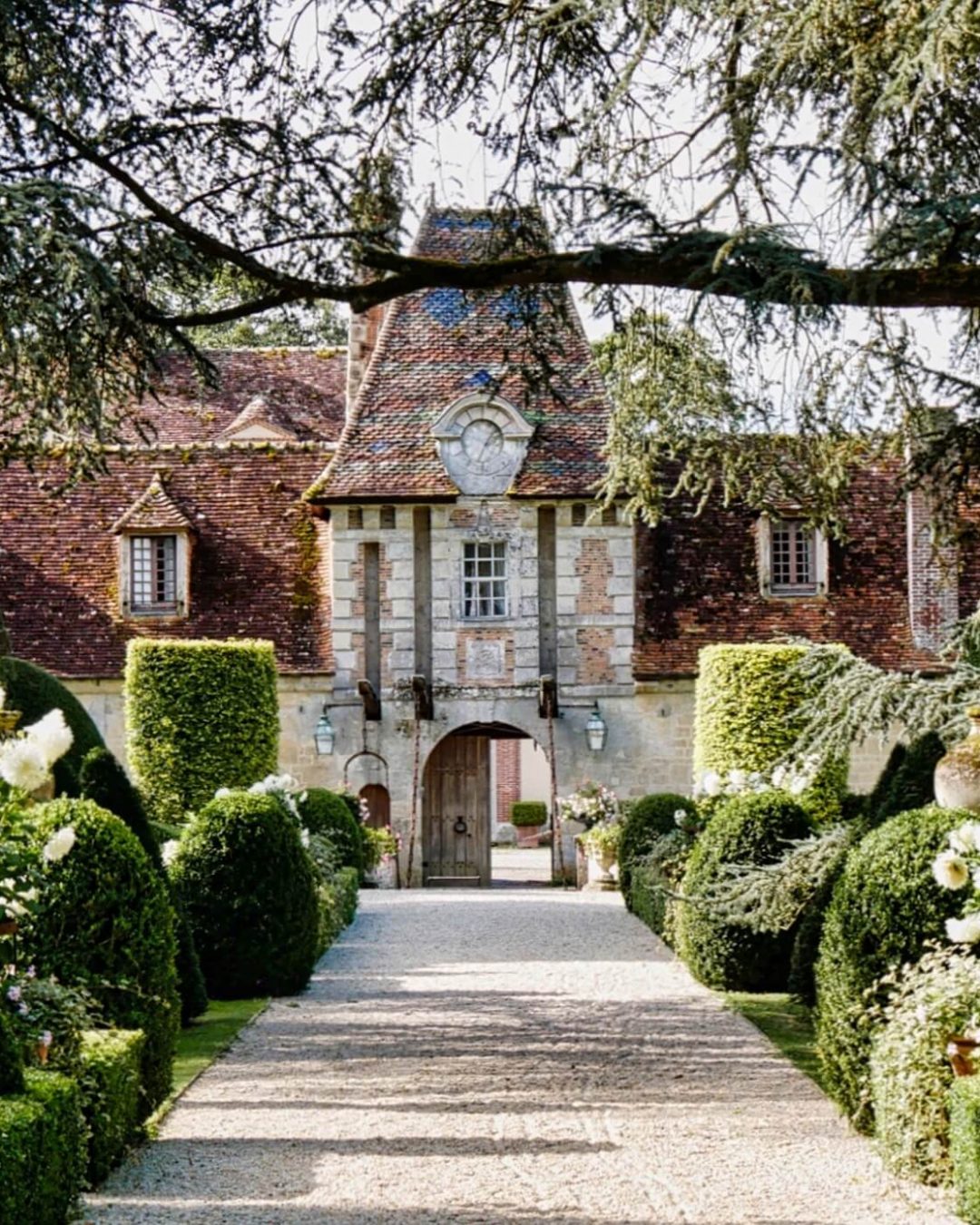 Boutemont Castle’s lush green hedges and blooming white flowers line the walking paths through the estate grounds.