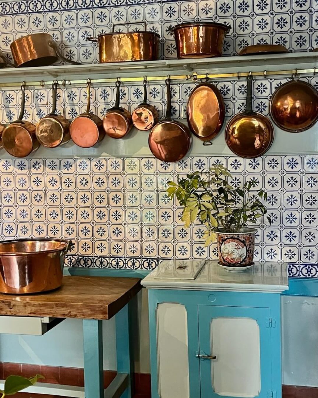 Normandy home kitchen with featuring array of copper pots and cookware.