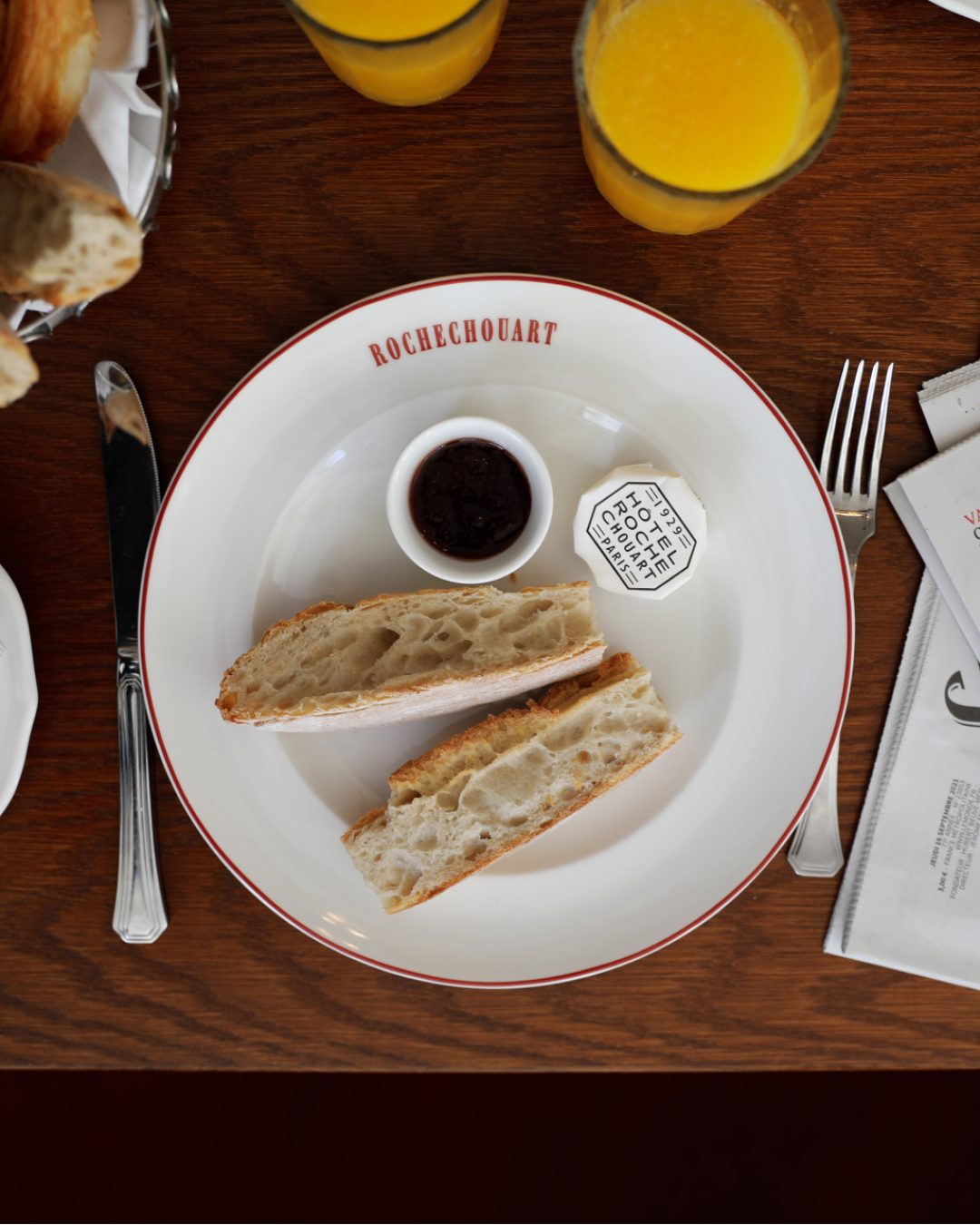 Breakfast spread and newspapers at the Rochechouart Hotel in Paris.