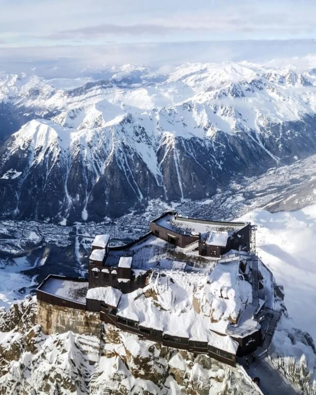 Chamonix ski resort perched on a snowy mountain, surrounded by the rugged peaks of the French Alps.