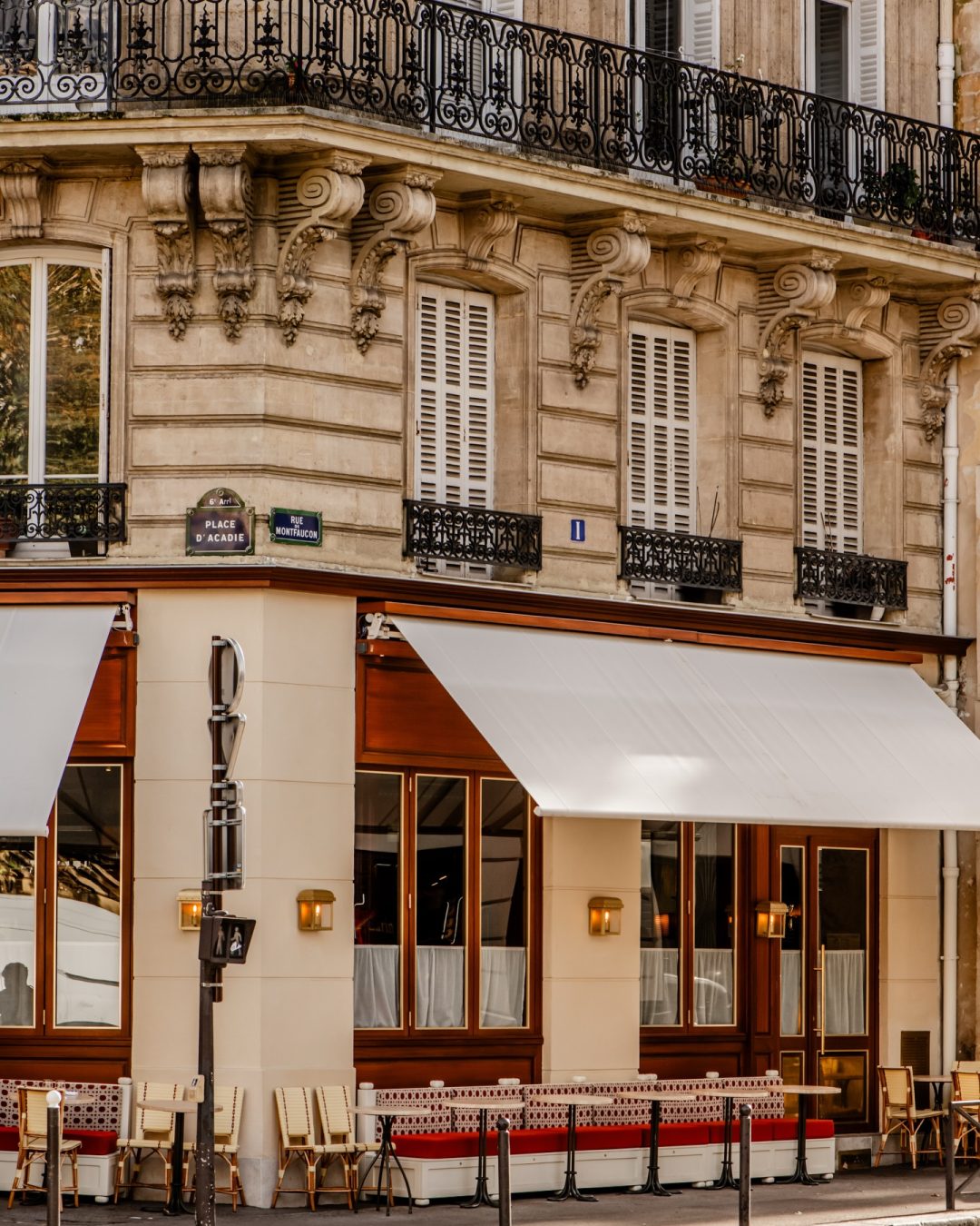 Brass restaurant exterior in Paris with a shaded terrace and intimate bistro dining tables.