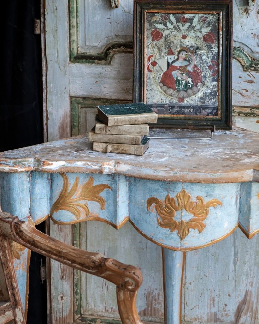 Rustic vintage table set with antique books and a French painting.