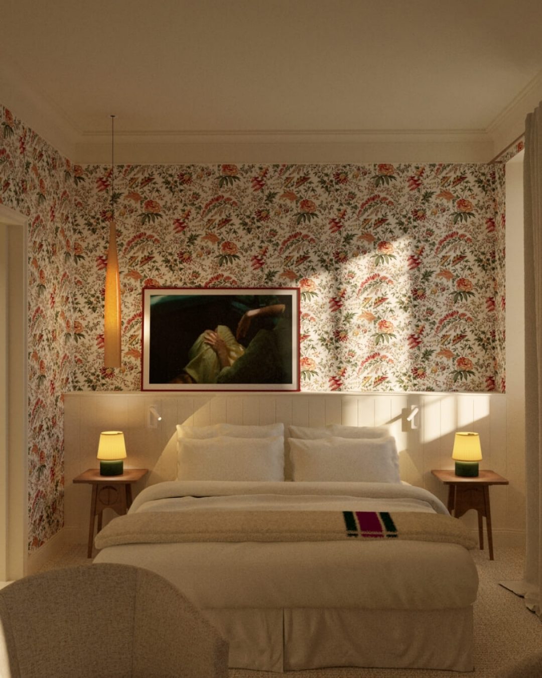 Interior of a room at Les Sources de Vougeot boutique hotel in Burgundy, France, featuring ornate wallpaper, mid-century modern accent tables, and plush bedding.